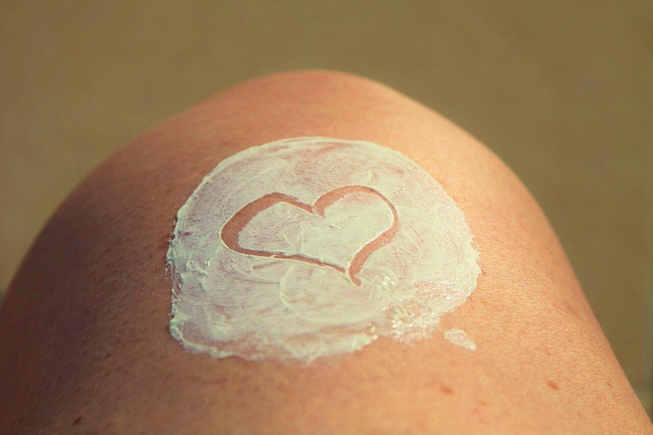 Image of a heart made with sunblock on someone's knee
